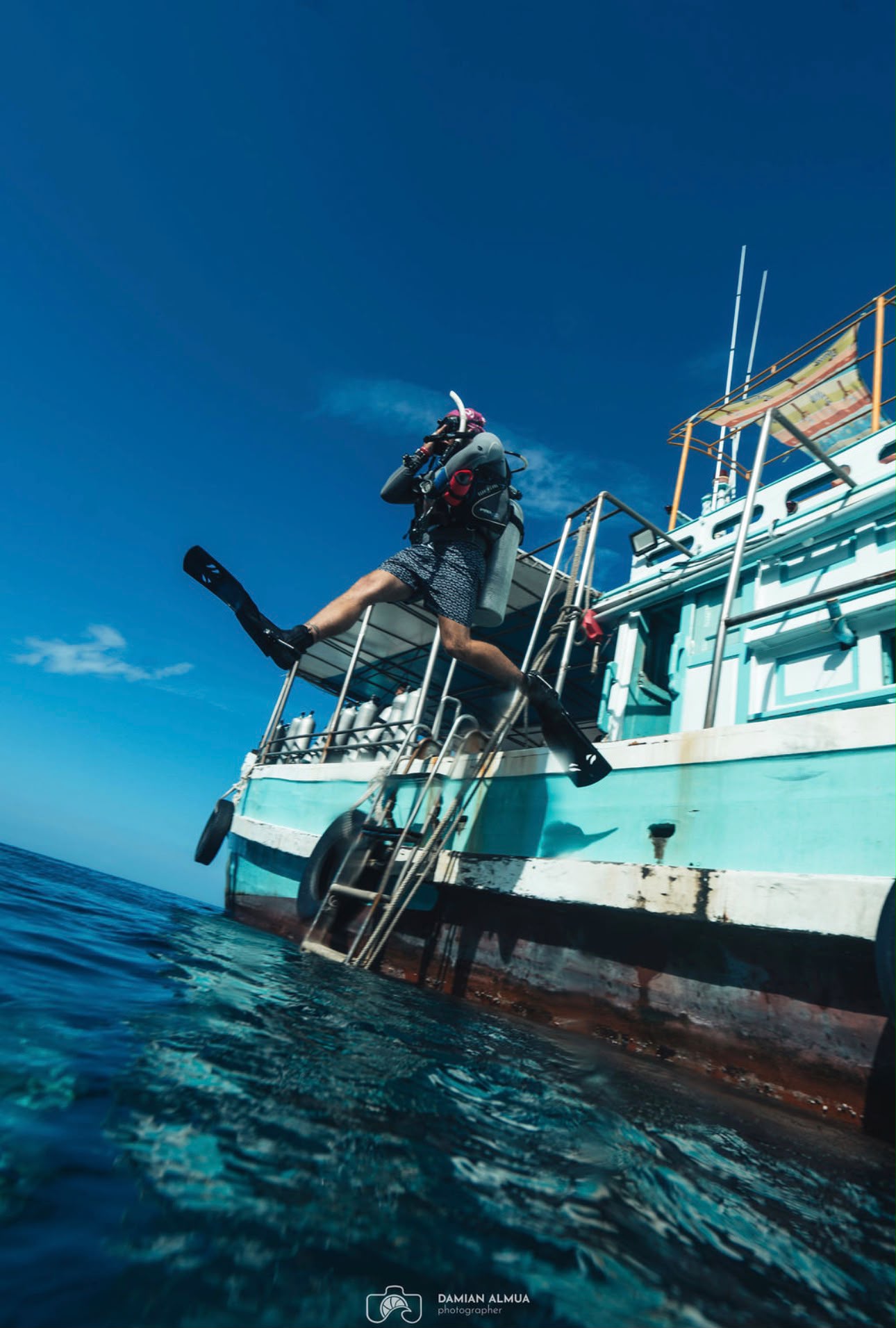 Diver stepping off a dive boat, mid-jump
