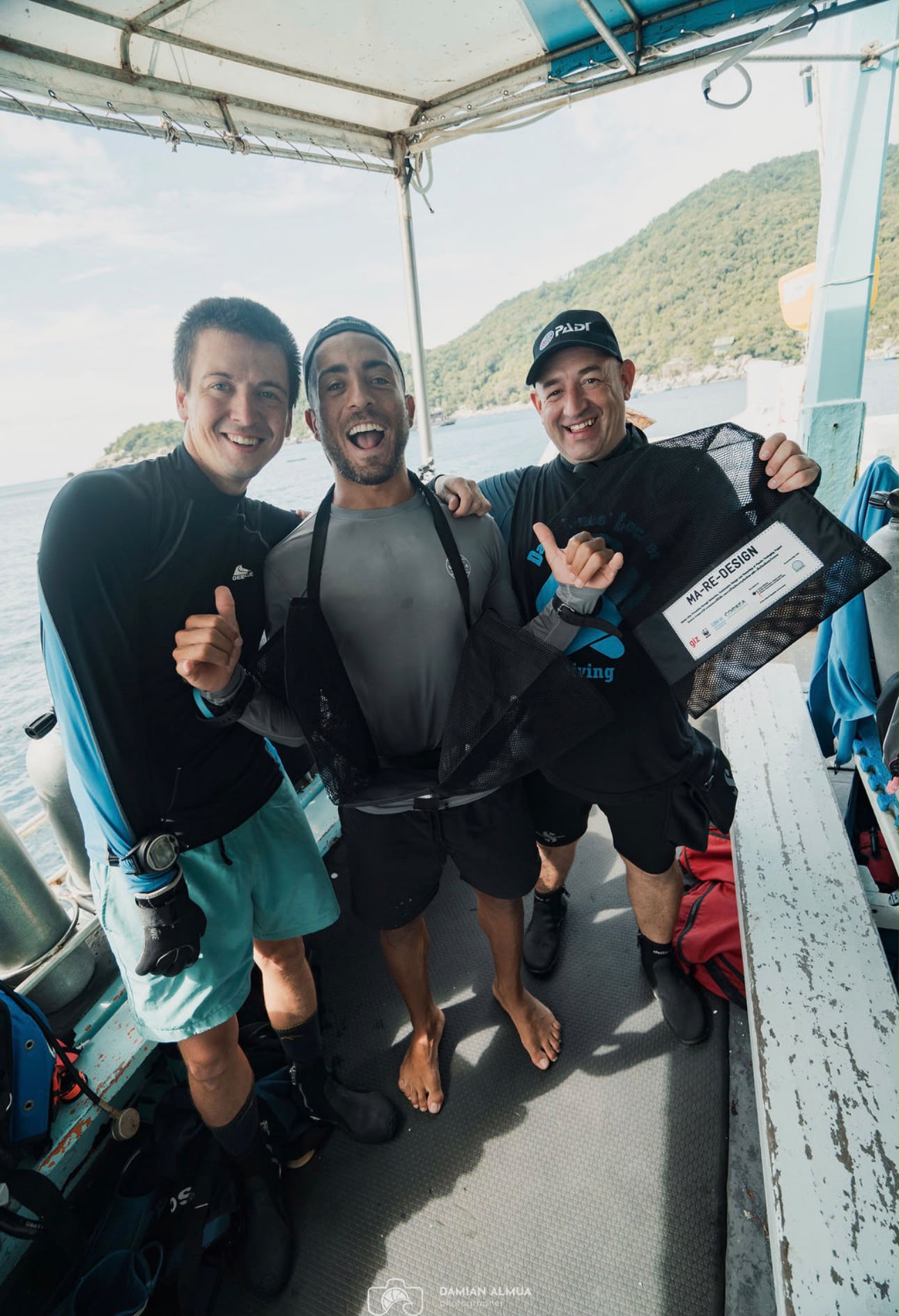 Walid and the dive team laughing together on the boat after a dive